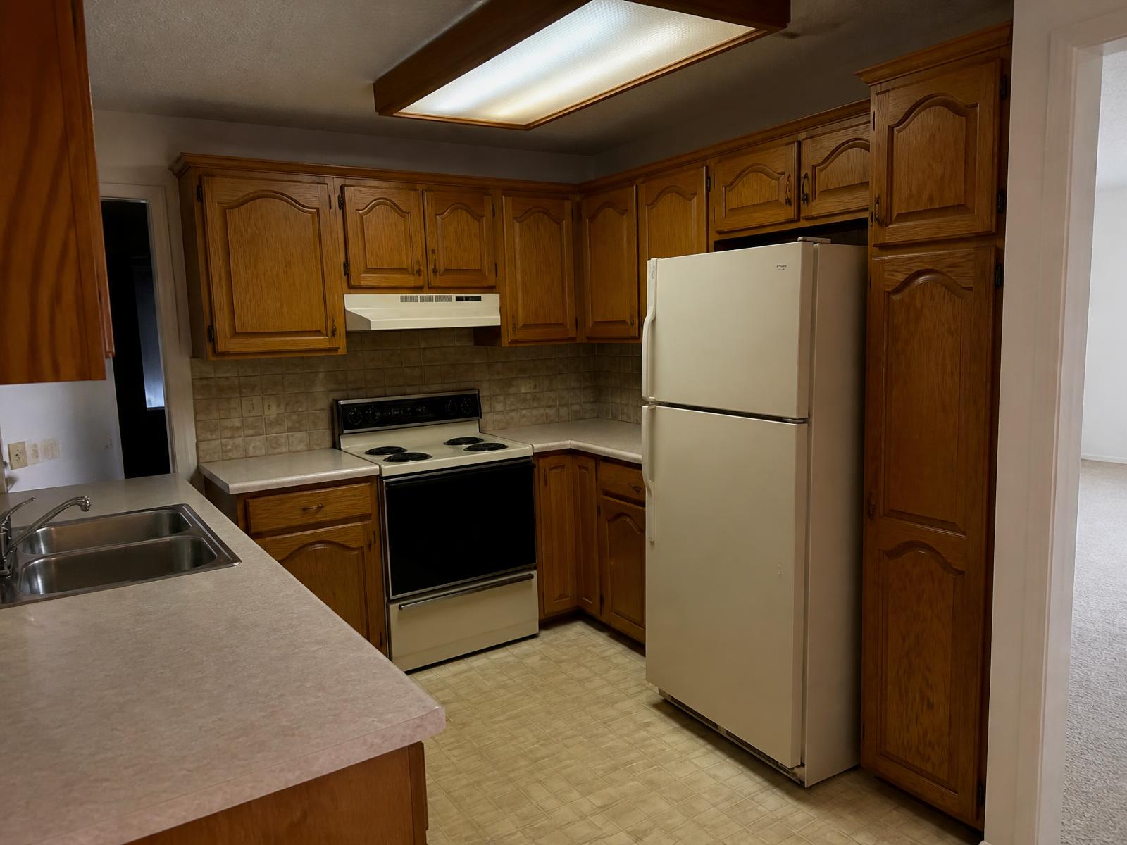 Before: Remodeled kitchen with navy cabinetry, white oak island, and marble countertops